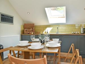 a kitchen with a wooden table with chairs and glasses at Perivale Lodge in Lydney