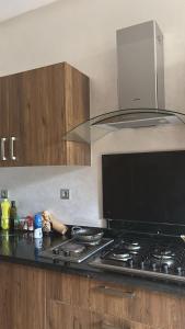 a kitchen with a stove top with a hood at Villa de luxe CGI avec piscine in Bouskoura