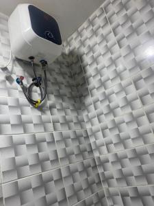 ein weißer Duschkopf an einer weiß gefliesten Wand in der Unterkunft Lifecamp Apartments in Abuja