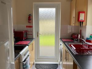 Saint CleerにあるHeligan - B6522のキッチン(シンク付)、窓付きのドアが備わります。