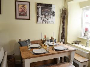 a wooden table with glasses and candles on it at Woodburn Cottage in Soutergate
