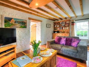 a living room with a couch and a table at Rhosson Chapel Cottage in St. Davids