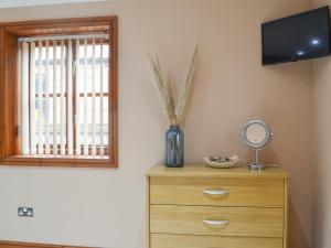 a room with a dresser with a mirror and a window at George's Gaff - E4432 in Ingoldmells