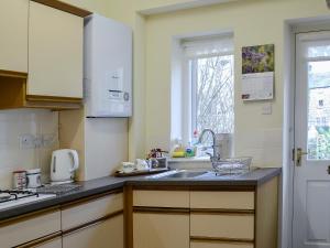 a kitchen with a sink and a counter top at Belgravia Cottage in Skipton