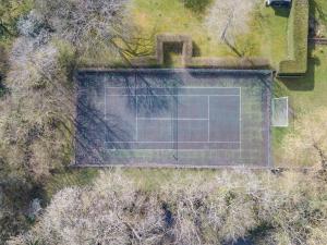 an overhead view of a tennis court with a tennis racket at Woolhouse Barn in Hunton +25 photos