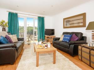Una sala de estar con dos sofás y una mesa. en Kingfisher-Qc1185, en Milford Haven