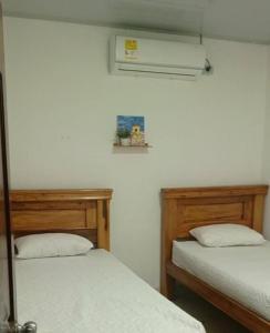 a room with two beds and a air conditioner at Casa Isabel in Santa Cruz de Mompox