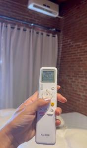 a person holding a remote control in their hand at Hotel Pousada dos Ipês in Minaçu