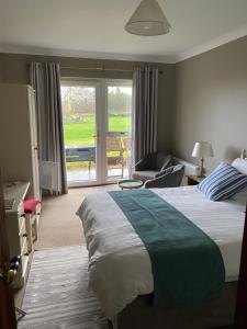 a bedroom with a large bed and a living room at Ocean Lodge B&B in Renvyle