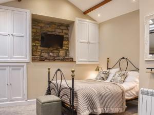 a bedroom with a bed and a tv on a wall at Uk45886 - The Studio At Cross House in Kirkby Lonsdale