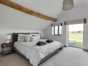 a white bedroom with a large bed and a window at The Maddocks - Uk36311 in Whitchurch