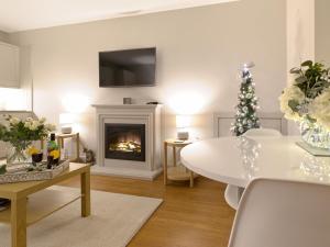 una sala de estar con una mesa y una chimenea en Lower Canterbury House, en Gattonside