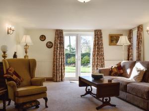a living room with a couch and a chair and a table at Beech Cottage in Somersal Herbert