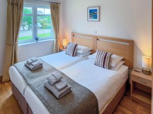 a bedroom with two beds with towels on them at No4 The Links Apartments in Brora