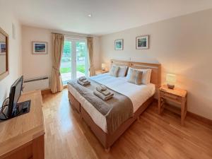 a bedroom with a large bed and a television at No4 The Links Apartments in Brora +11 photos