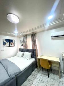 ein kleines Schlafzimmer mit einem Bett und einem Schreibtisch in der Unterkunft Lifecamp Apartments in Abuja