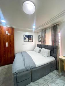 ein Schlafzimmer mit einem großen Bett in einem Zimmer in der Unterkunft Lifecamp Apartments in Abuja