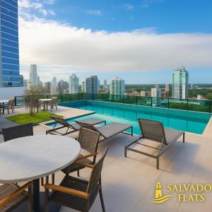 a balcony with tables and chairs and a swimming pool at Bahia Flats Facility View in Salvador