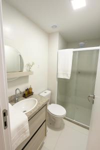 a bathroom with a toilet and a sink and a shower at Bahia Flats Facility View in Salvador +13 photos