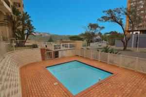 a swimming pool on a brick walkway with a bricknergynergy at 606 L'esclaier Cabanas - Seaside Paradise in Amanzimtoti