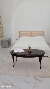 a coffee table sitting in front of a bed at La piazza in San Giorgio la Molara