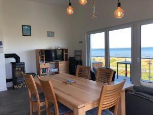 a dining room with a table and chairs and a television at Fewo Lia in Niederdorla
