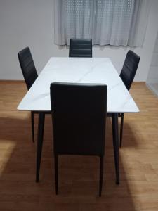 a white table with black chairs in a room at Apartman Bojan in Prnjavor