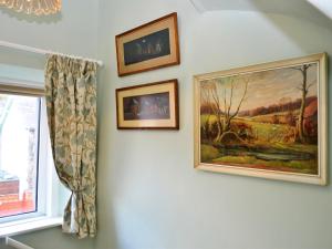 three pictures hanging on a wall next to a window at Catbells Cottage Keswick in Keswick
