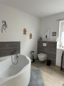 a bathroom with a bath tub and a toilet at SleepShop in Nordhausen +1 photo