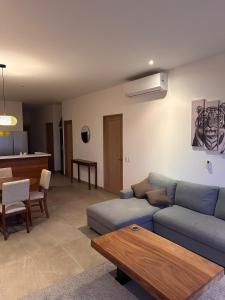 ein Wohnzimmer mit einem blauen Sofa und einem Tisch in der Unterkunft Charming apartment with a nice view in San Salvador