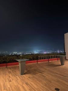 zwei Tische auf dem Dach eines Gebäudes bei Nacht in der Unterkunft Charming apartment with a nice view in San Salvador