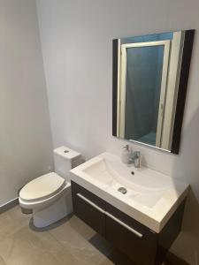 ein Badezimmer mit Toilette, Waschbecken und Spiegel in der Unterkunft Charming apartment with a nice view in San Salvador + 9 Fotos