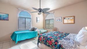 a bedroom with a bed and a chair and a ceiling fan at Cypress House in Puerto Peñasco