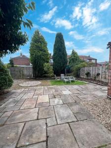 a stone patio with a bench in a yard at Family & Pet-Friendly 5pp, Parking, 20 min to City in Manchester