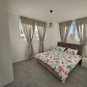 a bedroom with a bed and two windows at Lux Apartman Ilidza in Raskršće