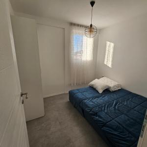 a bedroom with a blue bed and a window at Lux Apartman Ilidza in Raskršće