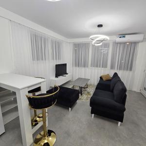 a living room with a couch and a table and a desk at Lux Apartman Ilidza in Raskršće