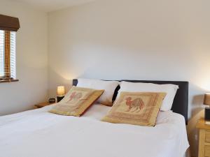 a bedroom with a white bed with two pillows at Church View - 24731 in Bearsted +7 photos