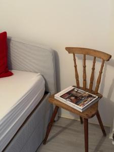a chair next to a bed with a magazine on it at Landhaus Johann in Mürzzuschlag