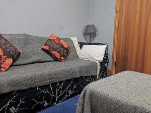 1 dormitorio con sofá y almohadas en White Wing - 29584, en Damerham