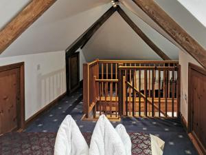 Una habitación abuhardillada con una cama y una escalera en White Wing - 29584, en Damerham