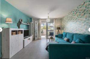 a living room with a blue couch and a tv at Tejita Beach in La Tejita