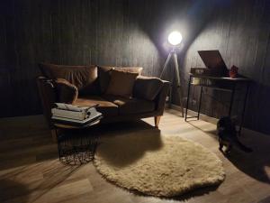 a living room with a couch and a table with a lamp at Logement cocooning 2-4 personnes avec Salle de jeux in Chémery