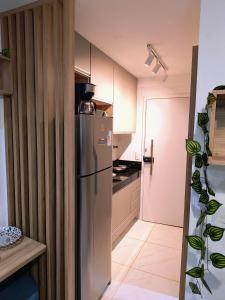 une cuisine avec un réfrigérateur en acier inoxydable et une porte dans l'établissement Porto de Galinhas - Cupe Garden Flat, à Porto de Galinhas