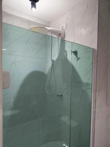 une salle de bain avec une douche avec une porte vitrée dans l'établissement Porto de Galinhas - Cupe Garden Flat, à Porto de Galinhas