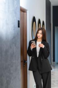 基希讷乌d'or Hotel的一位穿着西装的女士正在看手机