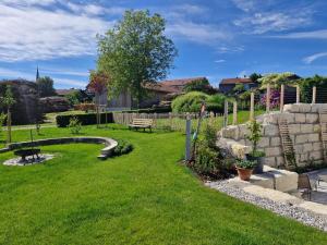 a garden with a bench and a stone fence at Ferienwohnung Niederbuchner in Chieming