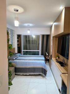 une chambre avec un lit et une télévision à écran plat dans l'établissement Porto de Galinhas - Cupe Garden Flat, à Porto de Galinhas