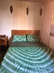 a bed with a green comforter in a bedroom at Palm and Pillow in Freetown +10 photos