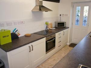 SwimbridgeにあるKingfisher - 30788の白いキャビネットと電子レンジを備えたキッチン